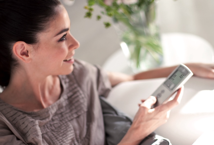 A woman using remote for blinds