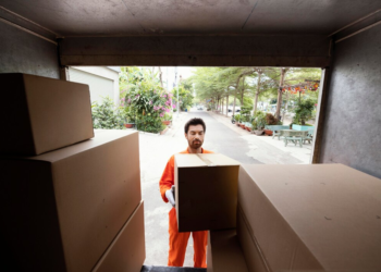 A man packing stuff in card boxes to move