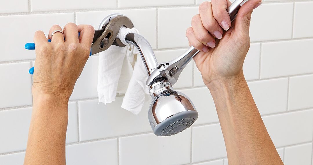 A person replacing a showerhead