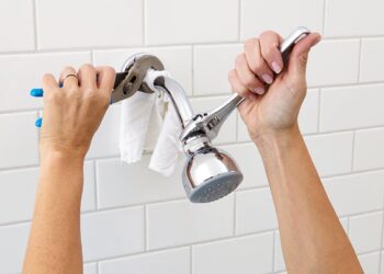 A person replacing a showerhead