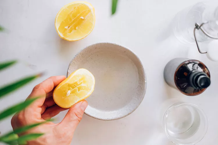 A women squeezing lemon in a bowl