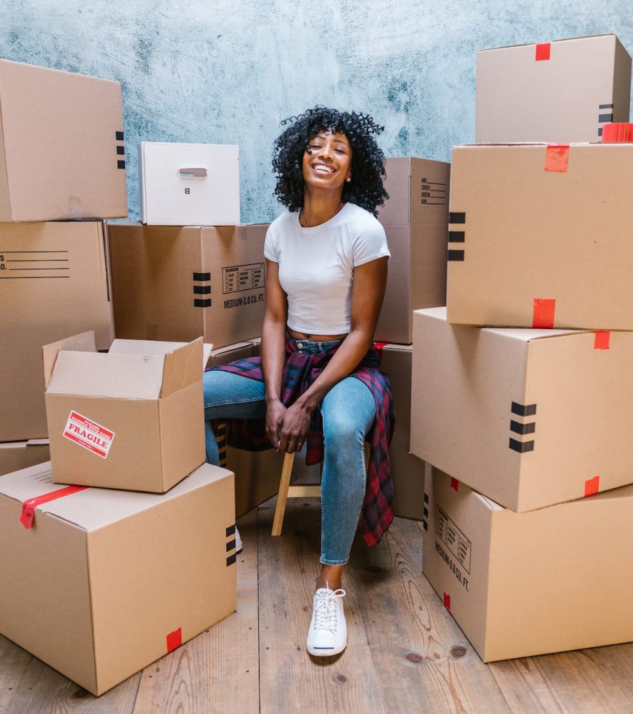 A women smiling with her packed stuff for moving