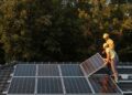 Two men installing solar panels on a home's roof
